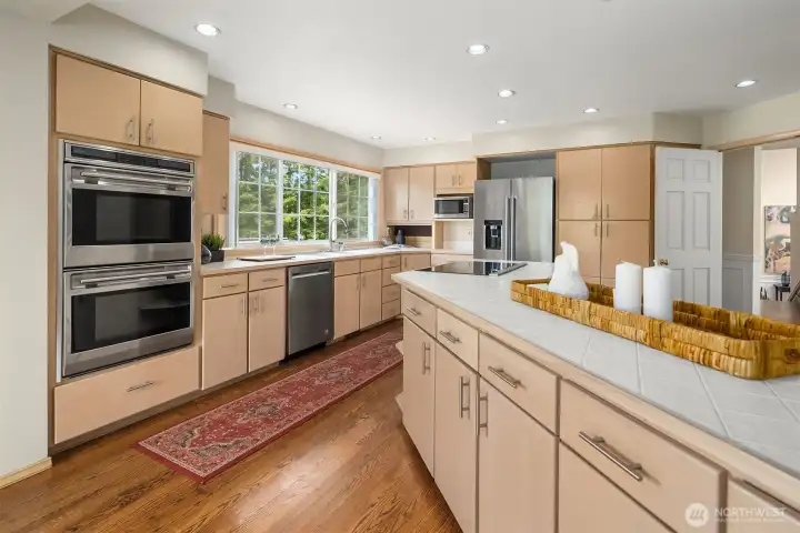 The expansive chef's kitchen is beautifully appointed with premium Wolf double ovens, a Thermador induction cooktop, abundant cabinetry, and generous prep space. The expansive chef's kitchen is beautifully appointed with premium Wolf double ovens, a Thermador induction cooktop, abundant cabinetry, and generous prep space.