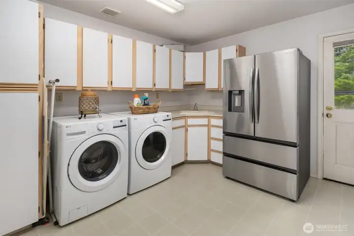 The spacious laundry/mud room provides abundant cabinetry and thoughtful functionality, with convenient access to the back deck, perfect for an effortless transition after poolside relaxation and outdoor activities. The spacious laundry/mud room provides abundant cabinetry and thoughtful functionality, with convenient access to the back deck, perfect for an effortless transition after poolside relaxation and outdoor activities.