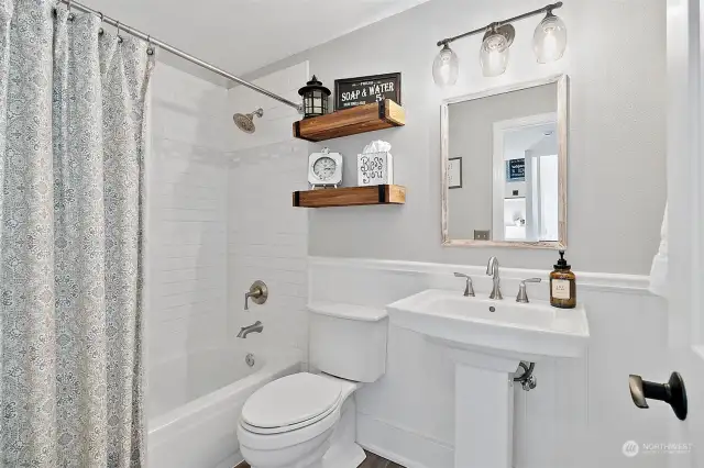 Downstairs full bathroom update. Re-glazed tub, new tile in shower and floors, updated vanity & lights.