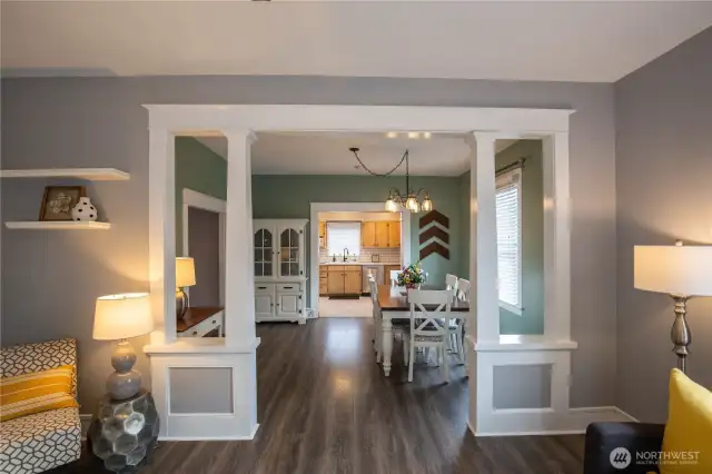 The living room has turn-of-the-century charm with see-thru column design, flowing through to the dining room