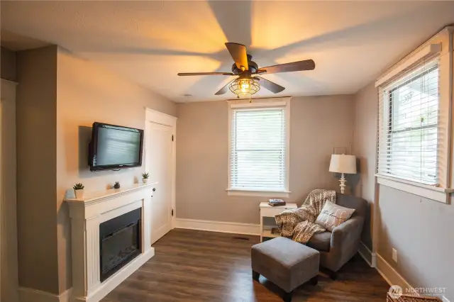 The cozy room is inviting as a family room, office, playroom, with a storage closet and door leading to the basement area.