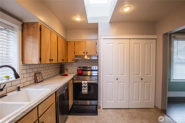 The kitchen is light and bright with skylight, new backsplash and stainless appliances.