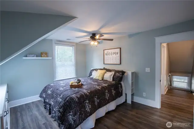 The primary bedroom is spacious with a skylight, built-in dresser, and ceiling fan.