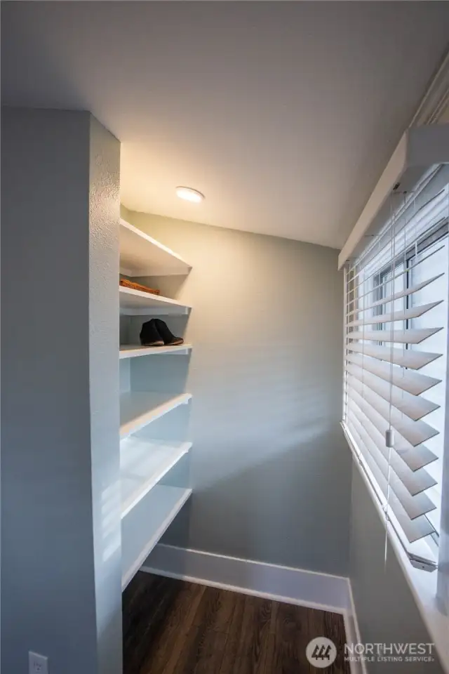 This nook area in the primary bedroom has shelving and is great for shoes, or anything you choose.