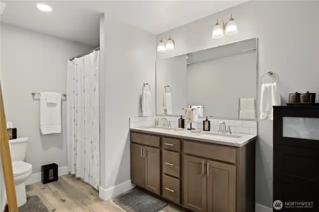 The primary suite with double sink vanity and easy walk-in shower.