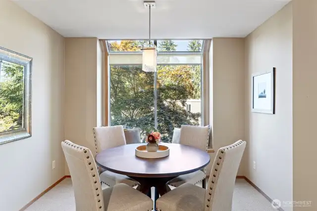 The dining area with lots of light, windows and an elegant ceiling fixture.