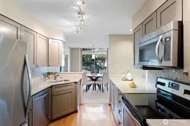 The updated kitchen with quartz countertops, updated stainless appliances, shaker style cabinet doors and herringbone backsplash.