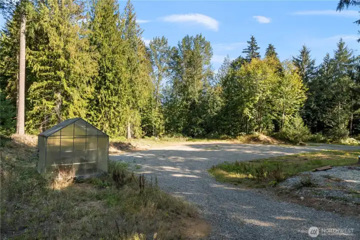 Lower area of lot with greenhouse and tons of level parking