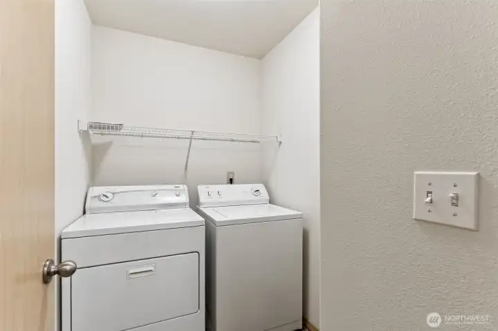 Utility room with full sized washer and dryer.
