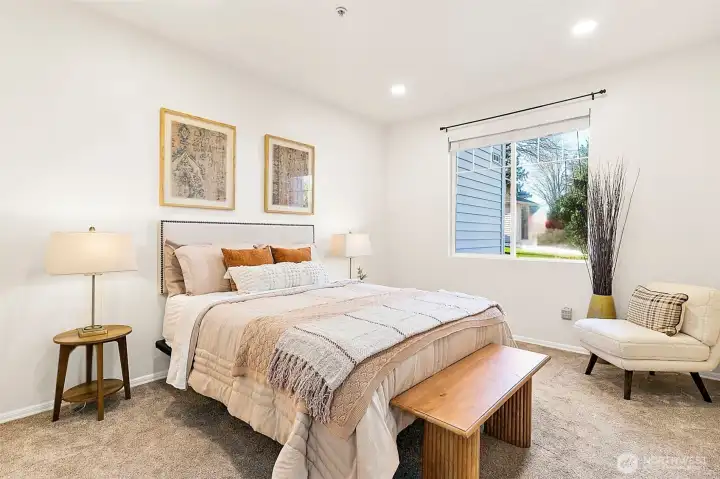 Large window and tall ceilings make this primary suite airy and inviting.