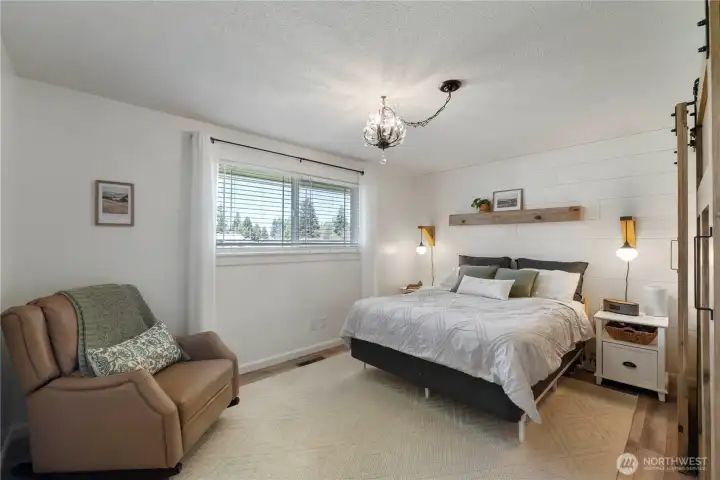 Master bedroom with shiplap and built in side lamps.