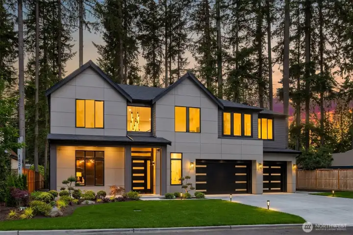 As evening settles in, warm interiors glow through expansive windows, creating a welcoming retreat surrounded by nature.