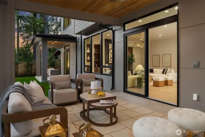 Large sliding doors create a seamless transition between the great room and covered outdoor living spaces, extending everyday living beyond the walls of the home.