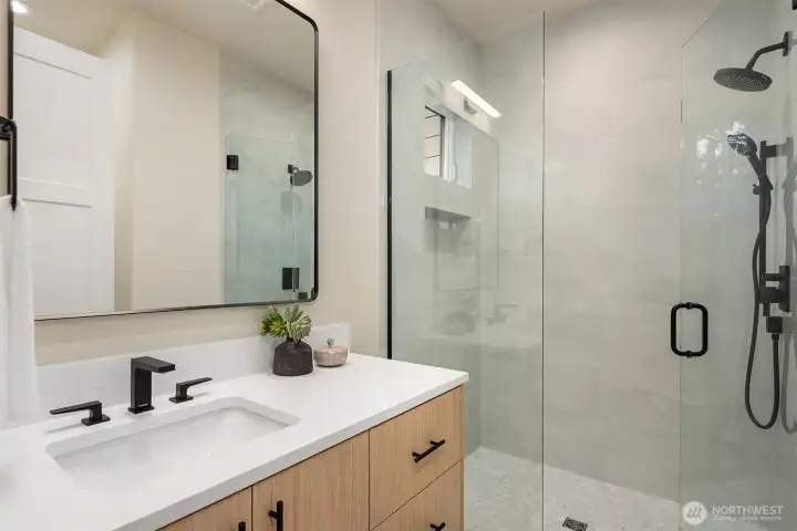 Complementing the main-level junior suite, the private bath combines refined finishes, thoughtful design, and everyday comfort.