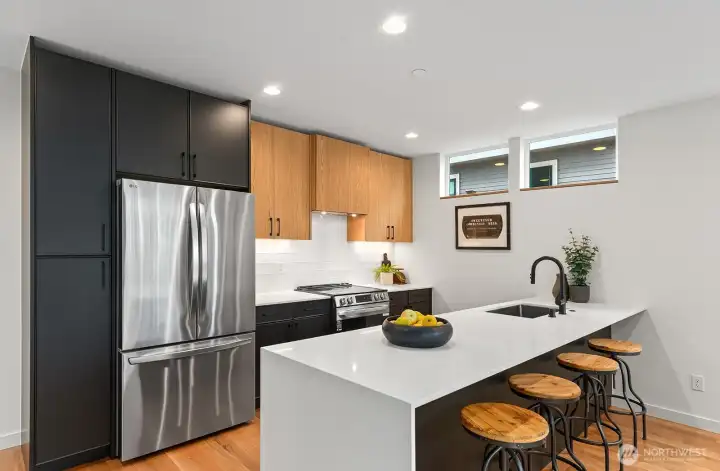 Abodian Cabinets, SS appliances, and quartz counter with bar top. Photo of model unit, 4116 B Burke Ave N - buyer to verify.
