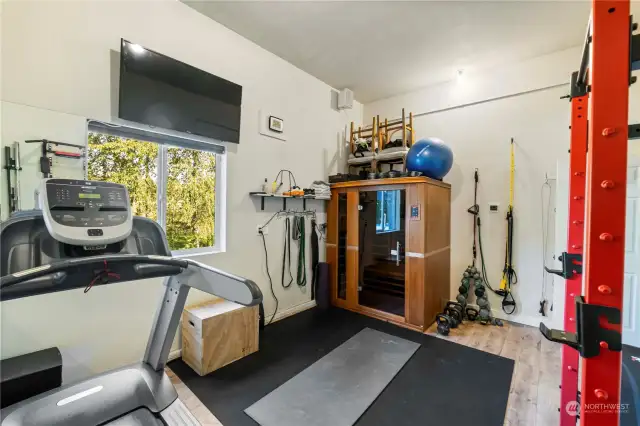 Check out this large sweet gym workout room with personalized sauna area looking out into private back yard off garage for year around workouts and happiness.