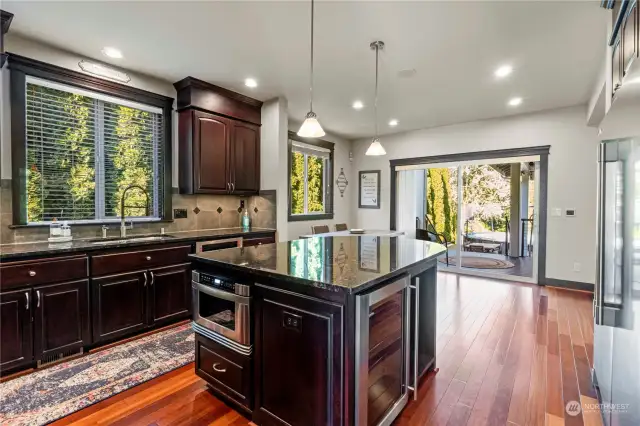 Check out this awesome chef's kitchen with ss appliances slab granite counters, tile back splash, recessed lighting and hanging pendant lighting. Double refrigerator and extra beverage refrigerator, wine rack and cherry hardwood flooring for easy clean up.