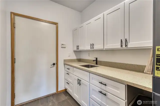 Newly remodeld utility room, lots of new cabinets, counter tops, sink and tile flooring.