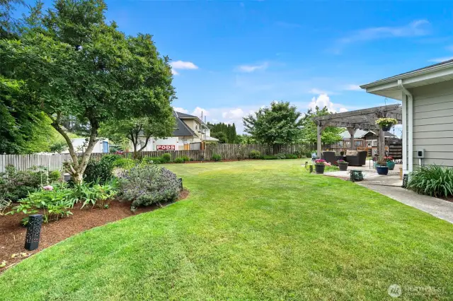 Side yard with greenhouse, garden space and shed.