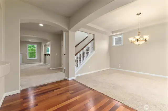 Hardwood flooring entryway leading into formal dining room and living room.