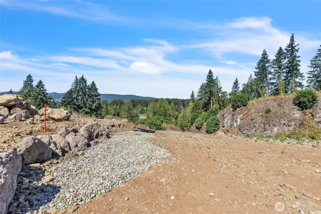 Gravel drainfield at end of rock wall