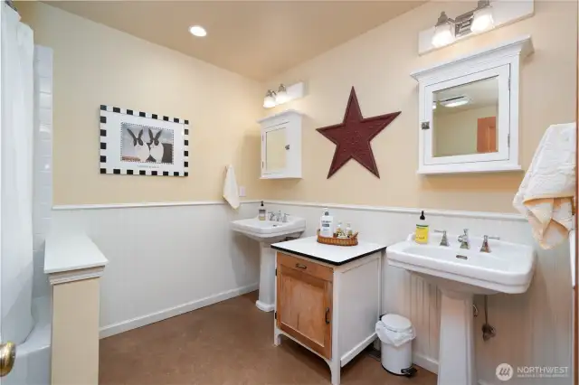 Main floor full bath with dual sinks, tub and shower.