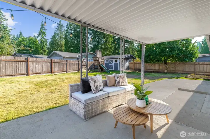 Back patio, play structure, and shed