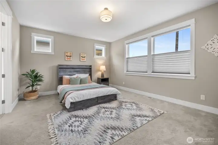 Primary bedroom on main with a spacious layout, soft natural light, and neutral finishes for a calm, relaxing feel