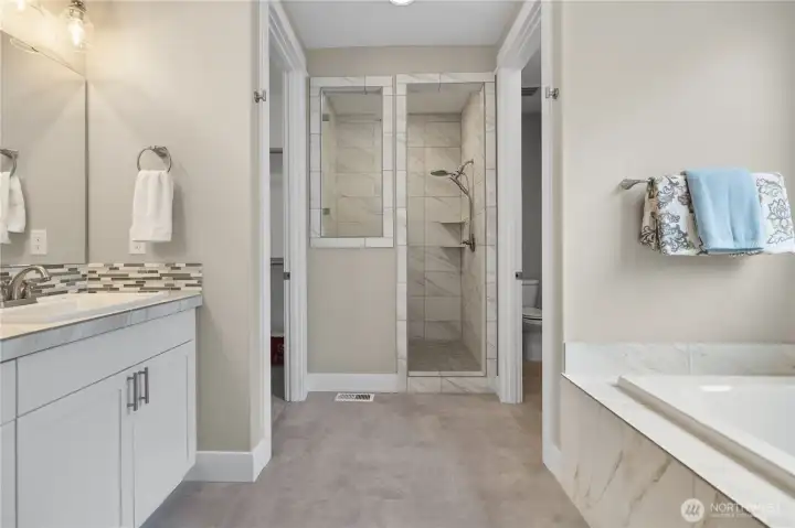Spacious primary bath with a walk-in tile shower, soaking tub, and modern finishes designed for comfort and convenience