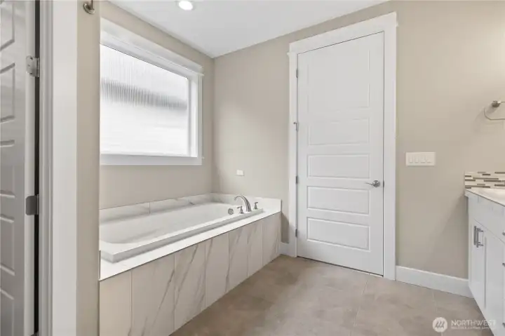 Relaxing soaking tub set in a bright, clean space that adds comfort to the primary suite
