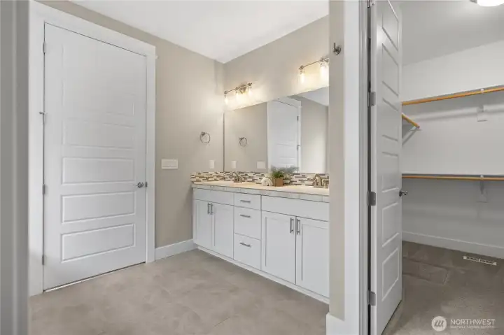 Primary bath includes dual vanities and direct access to a walk-in closet for added everyday functionality