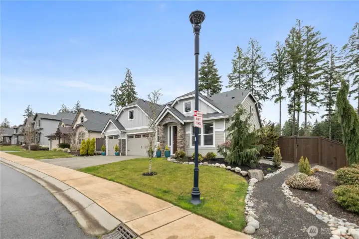 Welcoming front elevation with covered entry, manicured landscaping, and a clean, polished first impression