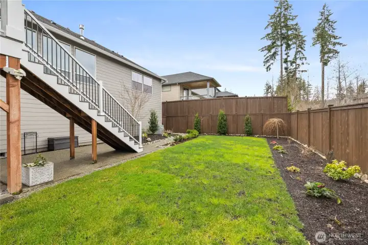 Thoughtfully designed outdoor space with deck access, open lawn, and a clean, low-maintenance layout