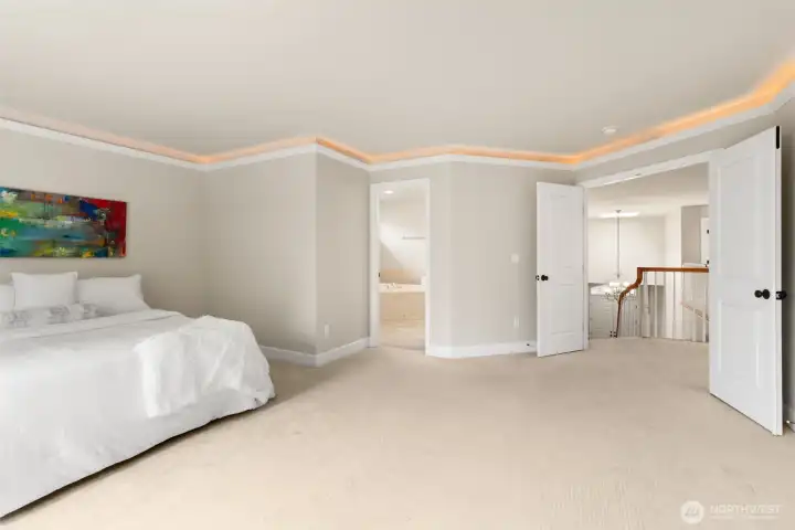 Double doors lead into the king-size+ primary suite. Note the mood lighting at the crown molding.