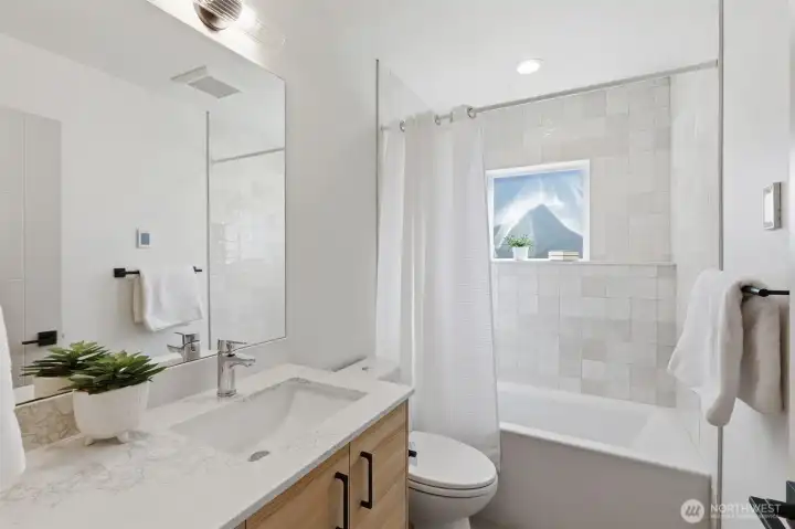 The full bathroom on the main level offers sleek finishes and a deep tub.