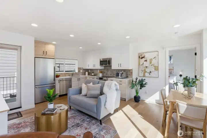 The upper level Great Room is drenched in natural light and connects living space to kitchen and the outdoors.