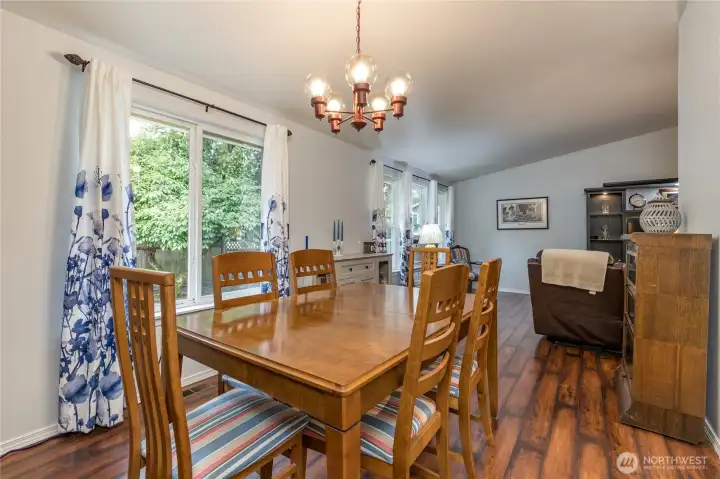 The formal dining room features vinyl plank flooring and a vaulted ceiling The formal dining room features vinyl plank flooring and a vaulted ceiling