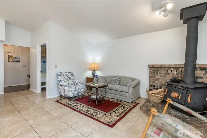 The family room also features a wood-burning corner stove with brick footings and surround. The vaulted ceiling nicely provides spaciousness The family room also features a wood-burning corner stove with brick footings and surround. The vaulted ceiling nicely provides spaciousness