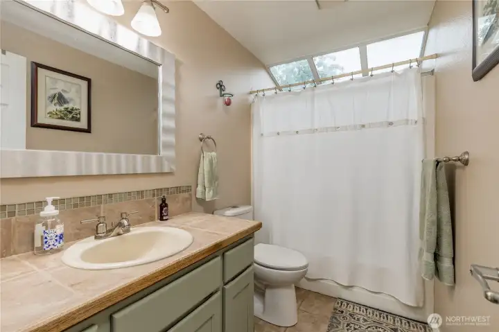 Bathroom with skylighting, a jetted tub and a shower. The flooring is tile Bathroom with skylighting, a jetted tub and a shower. The flooring is tile