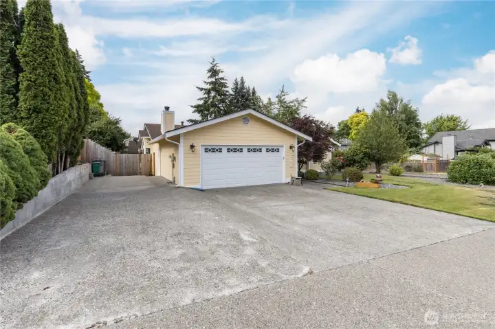The aggregate driveway, with RV parking to the left, and a gated entry access to the back yard The aggregate driveway, with RV parking to the left, and a gated entry access to the back yard