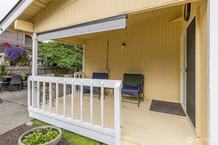 The back covered porch, providing both access and a seating area; the retractable awning will remain with the home too. The back covered porch, providing both access and a seating area; the retractable awning will remain with the home too.