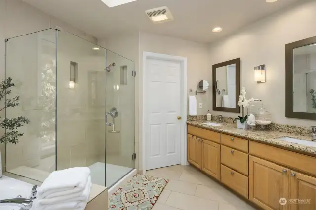 Another perspective of the 5-piece primary  bath reveals a spacious walk-in closet hidden  behind the door, adding convenience and  functionality to the suite.