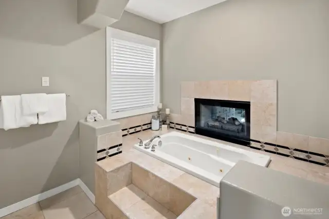 Jetted soaking tub with see through fireplace to primary sitting area.  Luxurious, private and relaxing!