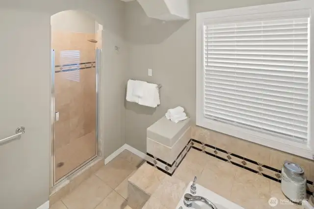 Spacious custom tiled primary shower with two shower heads.