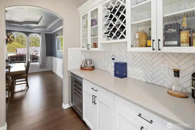Butler's pantry and bar area between dining room and kitchen.  Perfect for entertaining or private enjoyment.  Wine coolor/refrigerator, quartz counters and custom backsplash makes this area shine!
