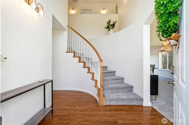 Step into the dramatic foyer with soaring ceilings, graceful staircase, and beautiful real oak flooring.