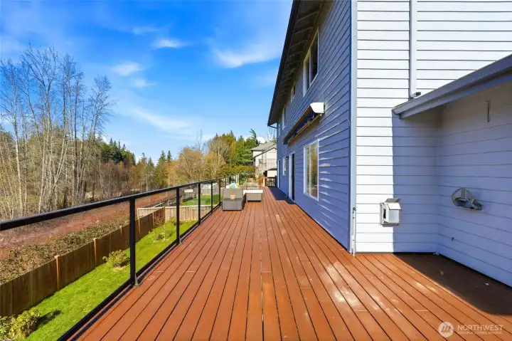 Expansive Trex deck spans the length of the home, with powder-coated aluminum and glass railings designed to maximize the sweeping golf course views.