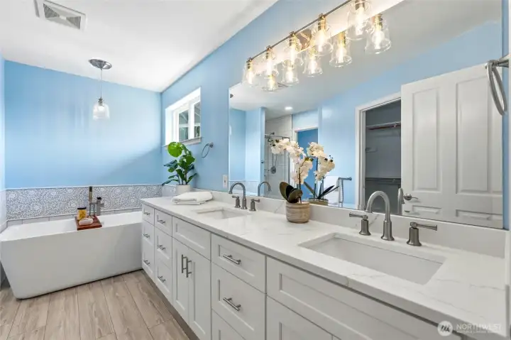 Spacious upstairs primary bath featuring a double vanity with quartz counters, soaking tub, and bright, refreshed finishes for a spa-like retreat.