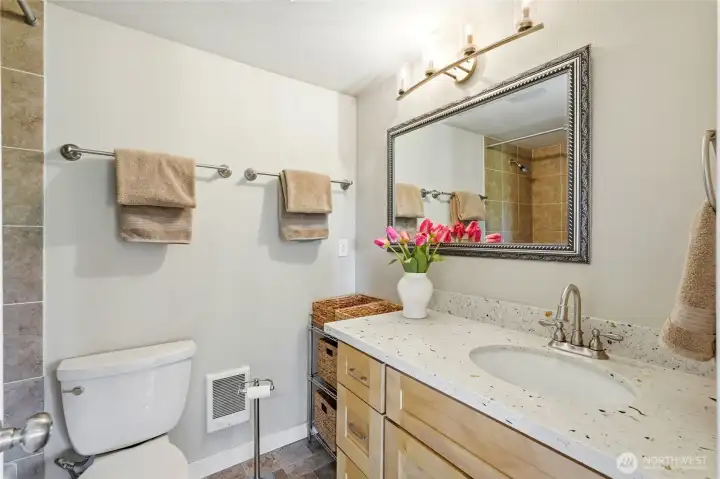 Convenient full bath in the daylight basement ADU with quartz vanity and tiled shower.