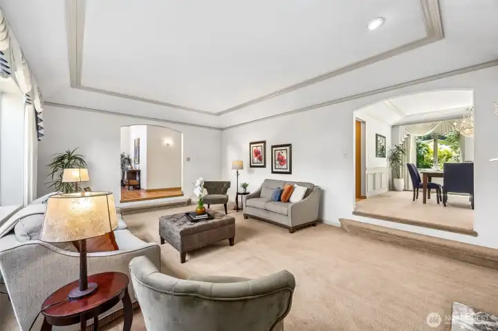 The formal living room includes plenty of space, ample daylighting, a wood burning fireplace and custom ceiling. The formal living room includes plenty of space, ample daylighting, a wood burning fireplace and custom ceiling.